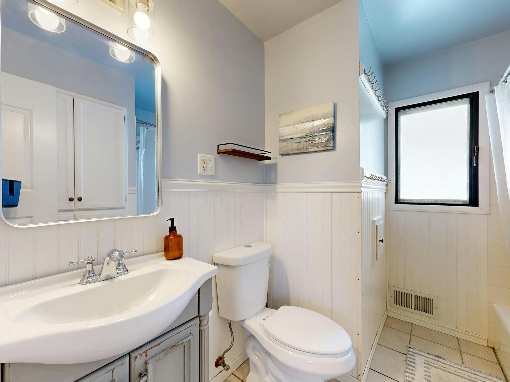 Jasna nowoczesna łazienka z umywalką, lustrem i minimalistycznym wystrojem