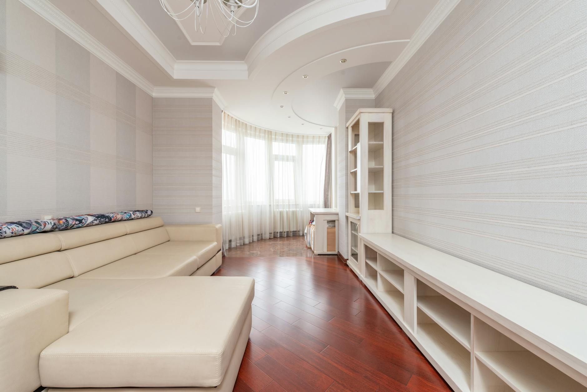 Jasny minimalistyczny salon z drewnianą podłogą i nowoczesnymi meblami