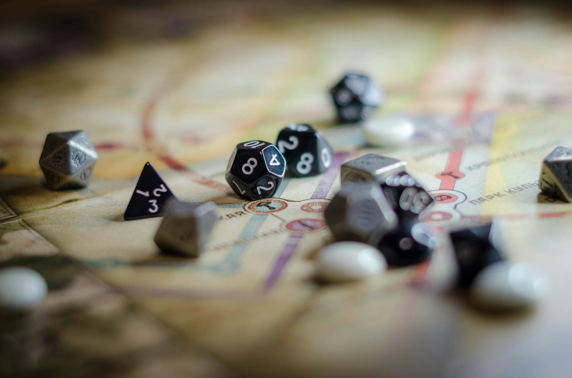 Czarno-białe kostki RPG rozrzucone na mapie planszowej
