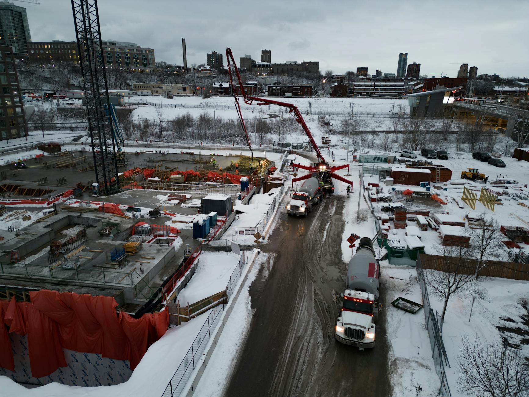 Domieszki do betonu zimą: co działa, a co tylko przyspiesza problemy Zimowy plac budowy z dźwigami i ciężarówkami widziany z lotu ptaka