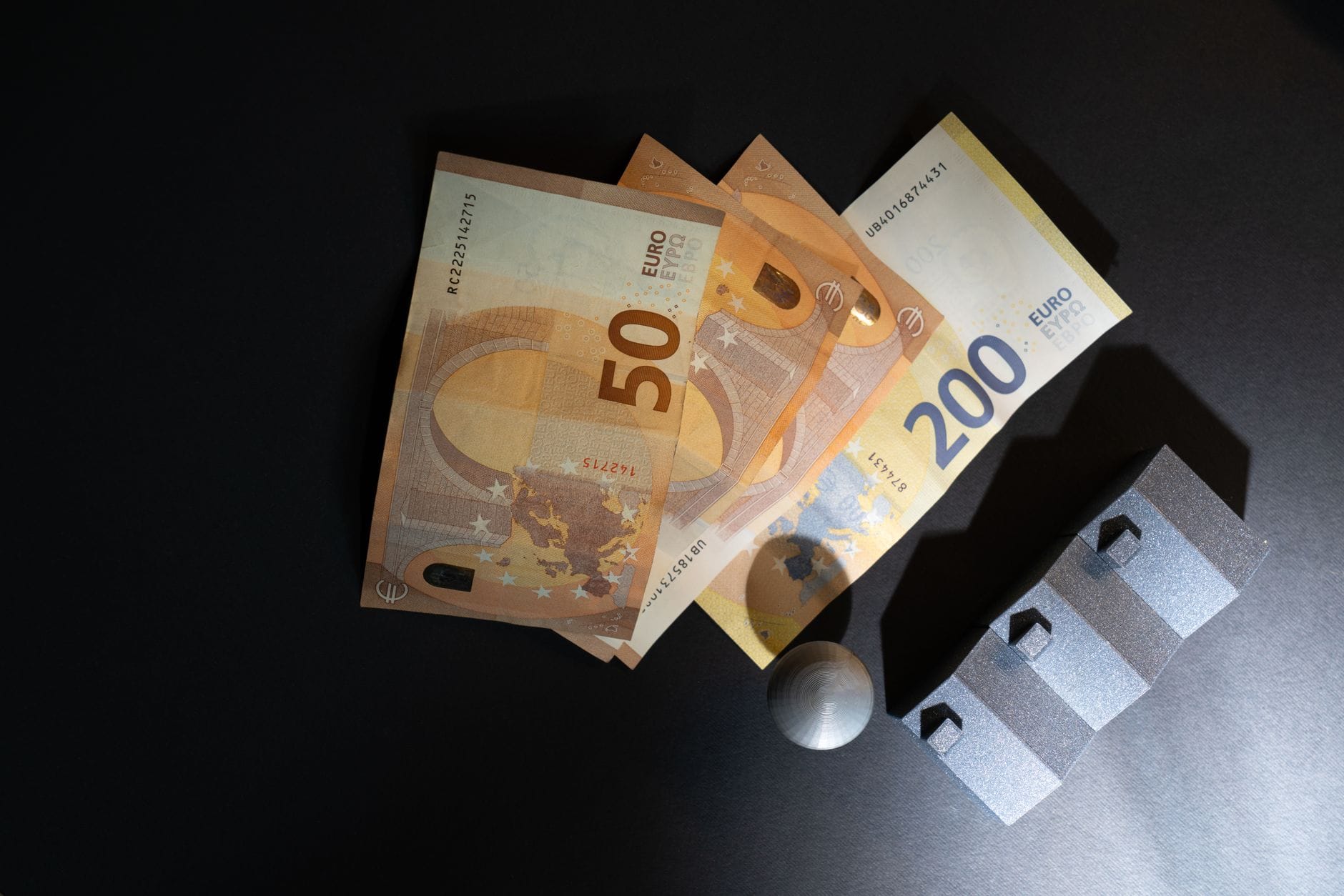 Banknoty euro i miniaturowe domy na ciemnym tle Banknoty euro i miniaturowe domy na ciemnym tle